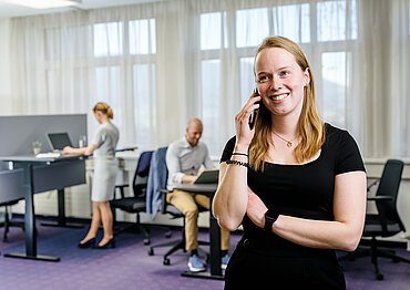 Foto von einer telefonierenden Frau im Coworking-Space