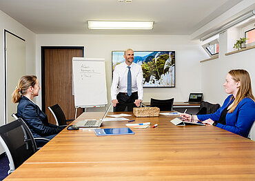 Foto vom Besprechungsraum mit 3 Personen