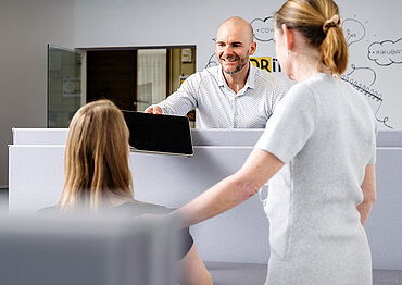 Foto von 3 Personen auf ihren Coworking-Plätzen